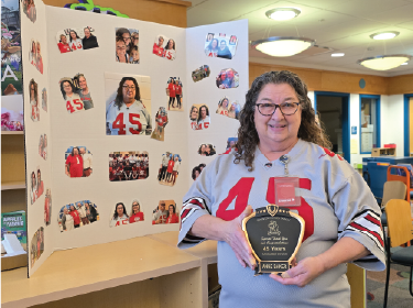 woman holding plaque wearing a jersey with the number 45 on it